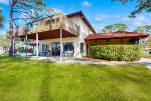 ein Haus mit einer Terrasse und einer Liegewiese in der Unterkunft Peaceful Pinecone in Sarasota