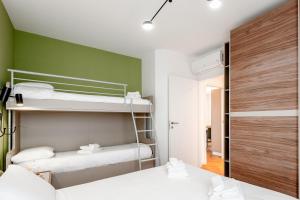 a bedroom with two bunk beds and a green wall at StayEasy Argelati40 - Penthouse with 2 bedrooms, 2 bathrooms and terrace - Navigli in Milan