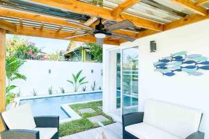 une terrasse avec un ventilateur de plafond et une piscine dans l'établissement Atlantis Villages Poseidon, à Tela