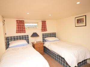 2 camas individuales en un dormitorio con ventana en 2 Bed in Barnstaple LCOBB, en Chittlehampton