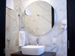 een badkamer met een wastafel en een spiegel bij Hotel Mayis in Oaxaca City