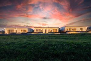 Ein paar Häuser auf einem Feld mit Sonnenuntergang in der Unterkunft Villas Cardás in Sanxenxo