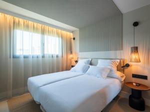 ein Schlafzimmer mit einem großen weißen Bett und einem Fenster in der Unterkunft Villas Cardás in Sanxenxo + 17 Fotos