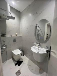 a bathroom with a sink and a toilet and a mirror at شقق سمارت انترى بالملقا in Riyadh