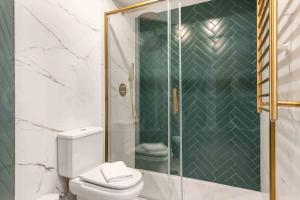 ein Bad mit einem WC und einer Glasdusche in der Unterkunft Newly refurbished glamorous flat in the center by REMS in Málaga