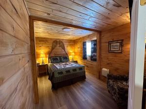 um quarto com uma cama num chalé de madeira em Rowe's Adirondack Cabins of Schroon Lake em Schroon Lake