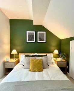 um quarto com paredes verdes e uma cama com uma almofada amarela em Charming home near Gatwick Airport em Crawley