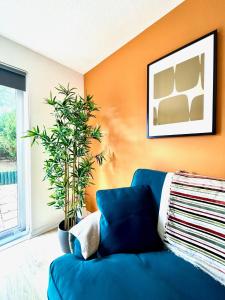 a blue couch in a living room with an orange wall at Charming home near Gatwick Airport in Crawley