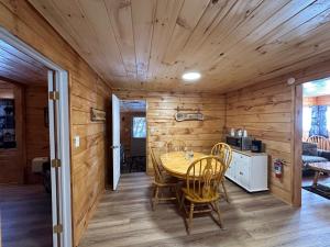 a dining room with a table and chairs at Rowe's Adirondack Cabins of Schroon Lake in Schroon Lake