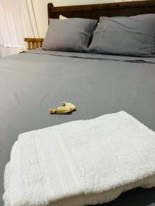 - un lit avec une couverture blanche et un téléphone jaune dans l'établissement HOTEL POUSADA MACHADO, à Frutal