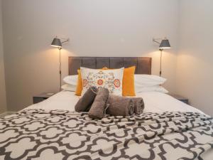 a bedroom with a large bed with two lamps at Windermere in Kendal