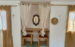 einem Tisch mit 2 Stühlen und einem Spiegel an der Wand in der Unterkunft UcúLila in Sisal