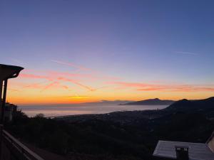 a view of the ocean at sunset at Appartamento Terrazza Vista Mare in Liguria, Genova, 5 Terre - gigiohomes in Cogorno