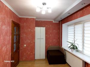 a living room with red walls and a window at Подобова оренда двокімнатної квартири Старичі in Starychi