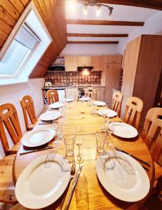 einem großen Holztisch mit Tellern und Gläsern darauf in der Unterkunft Ferienwohnung Naturoase Quasthoff in Neustadt an der Weinstraße