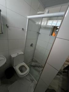 a bathroom with a toilet and a glass shower at Hotel Delavy in Chapecó