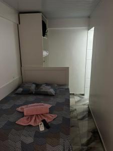 ein kleines Schlafzimmer mit einem Bett, auf dem zwei Handtücher liegen in der Unterkunft Hotel Delavy in Chapecó