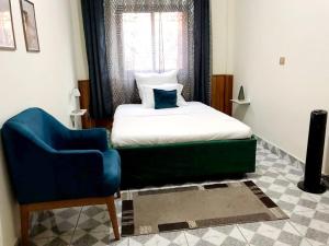 a bedroom with a bed and a blue chair at NS Immo Yaounde Cameroun in Yaoundé +82 photos