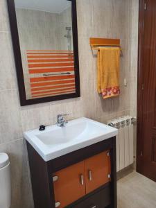 a bathroom with a white sink and a mirror at Apto. Vista Bahía Santander in Pontejos