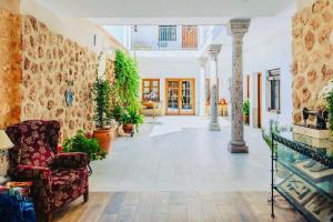 una sala de estar con una silla y algunas plantas en Hotel Rural Sisapo en Almodóvar del Campo