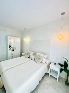 um quarto branco com uma grande cama branca com almofadas em Hotel Rural Sisapo em Almodóvar del Campo