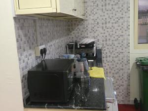 - un comptoir de cuisine avec évier et four micro-ondes dans l'établissement Ruby Star Hostel Dubai Couples Partition 303, à Dubaï