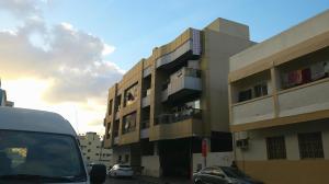 a building with cars parked in front of it at Ruby Star Hostel Dubai 303 in Dubai