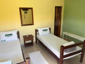 a room with two beds and a mirror at Hotel Fazenda Brejo in Saloá