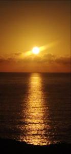 a sunset over the ocean with the sun setting at Medano Beach Villas in El Médano