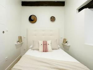 a white bedroom with a bed with a white headboard at Apartamento de diseño en Laredo centro in Laredo