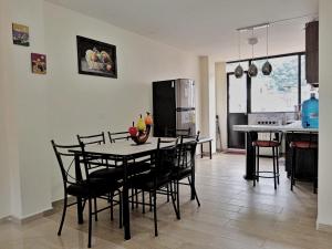 Hospedaje Charlie's House في بانوس: مطبخ وغرفة طعام مع طاولة وكراسي