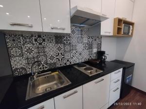 a kitchen with a sink and a black and white wallpaper at Esmeralda in Douar el Hafey