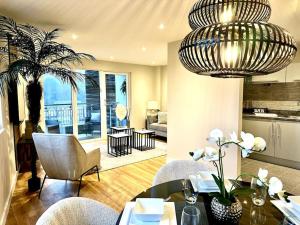 a living room with a chandelier and a table and chairs at Exclusive Marina View Apartment Free Parking in Cardiff