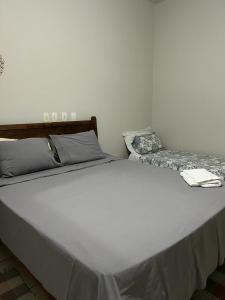 - un grand lit blanc dans une chambre dans l'établissement HOTEL POUSADA MACHADO, à Frutal