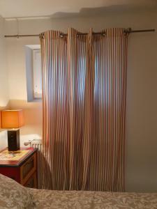 a curtain in a bedroom with a bed and a desk at La Romantique in Paris