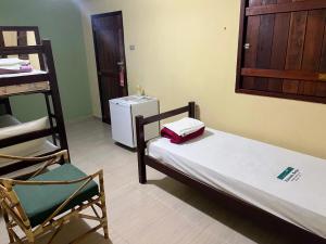 Cette chambre comprend un lit, une chaise, des lits superposés et un lavabo. dans l'établissement Hotel Fazenda Brejo, à Saloá