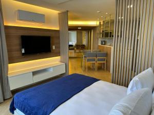 1 dormitorio con 1 cama y TV de pantalla plana en HY Beach Flats - International, en Recife