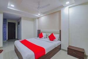 a bedroom with a large bed with red pillows at Collection O Greenwood in Ahmedabad