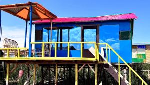 uma casa numa plataforma com cadeiras em casa ecológica em Puno