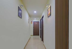 a hallway with a door and two pictures on the walls at Collection O Greenwood in Ahmedabad