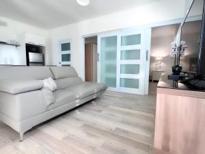 Secret View في إيزابيلا: غرفة معيشة بها أريكة بيضاء وتلفزيون