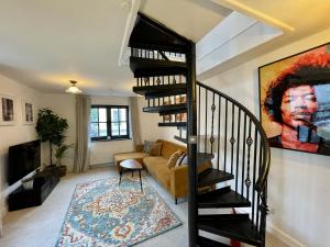 uma escada em espiral numa sala de estar com um sofá em Cosy Oasis in the Heart of Clifton Village em Bristol