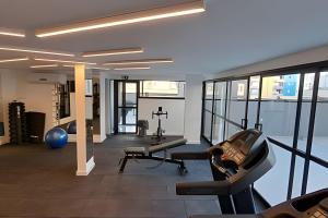 un gimnasio con dos cintas de correr y una cinta de correr en Studio Pratico - Centro Poços de Caldas en Poços de Caldas