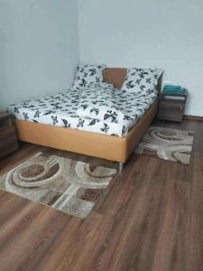 a bed in a room with a wooden floor at CASA OANA in Radoşi