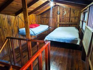 Zimmer mit 2 Betten in einer Holzhütte in der Unterkunft Oasis del Bosque 