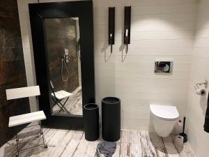 a bathroom with a toilet and two black trash cans at Villa Amare in Uddevalla