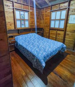 ein Schlafzimmer mit einem Bett in einer Holzhütte in der Unterkunft Oasis del Bosque 