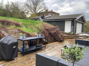 un homme debout sur une terrasse à côté d'une maison dans l'établissement Villa Amare, à Uddevalla