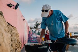 a man is cooking food in a grill at Sand Dollar Bonaire in Kralendijk