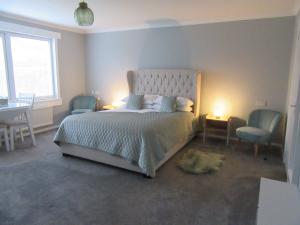 a bedroom with a bed with two chairs and a table at Sgurr Alasdair B&B in Portree